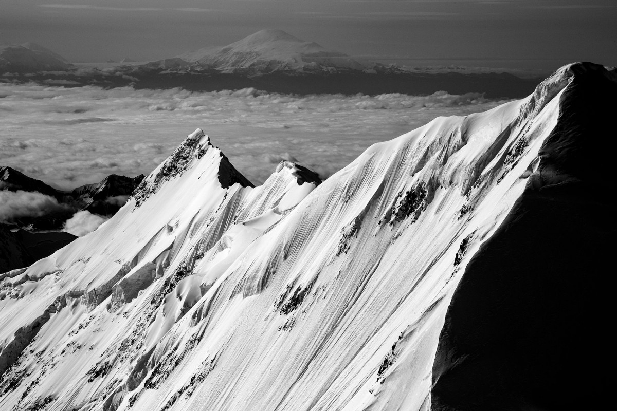 Looking across the face of Mt. Kimball in the Alaska Range as Mt. Sanford looms in the background in the Wrangell Mountains.